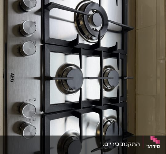 כיריים גז עם ארבעה מבערים וכפתורי שליטה